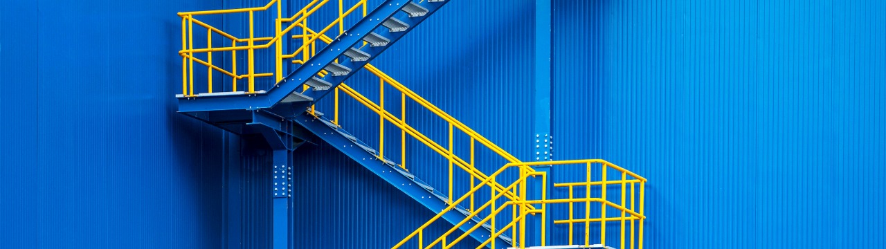 A blue wall with a yellow stairs illustrates the path to retirement, inviting all ages to explore new opportunities