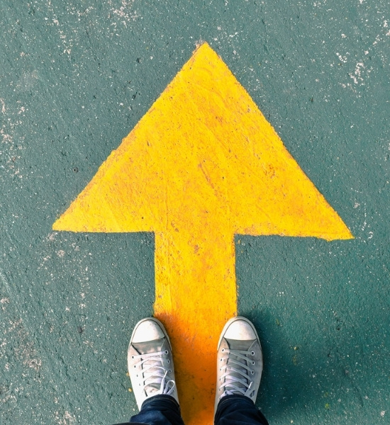 Photo of arrow painted on row pointing upwards.