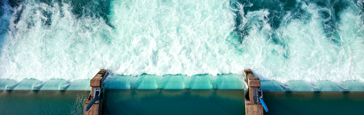 Aerial view of ocean waves crashing over a seawall