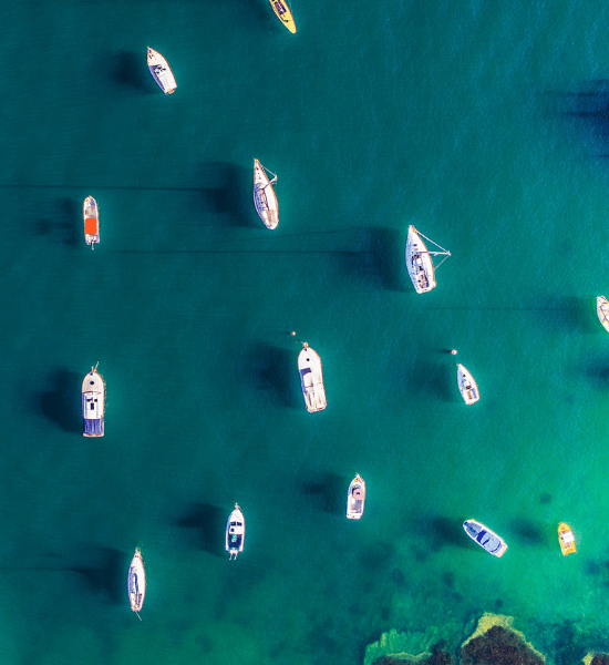 Boats anchored in turquoise water viewed from above representing research spotlight of inflation hedging revisited