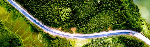Aerial view of a winding road through green landscape representing the path to after-tax portfolio management.