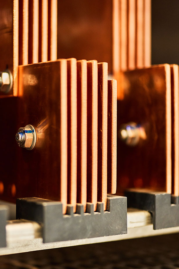 Close-up of copper busbars used for power distribution and grounding.