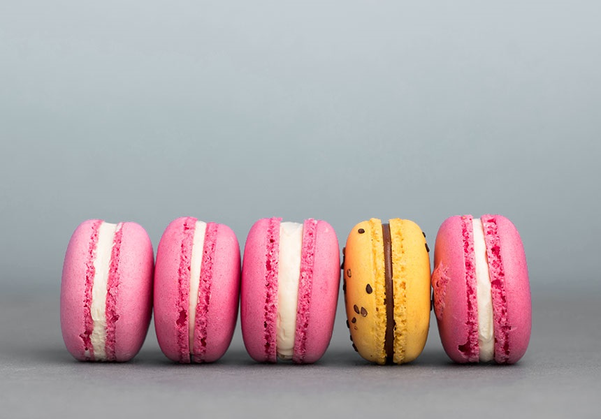One differently coloured macaron among several uniformly coloured ones.