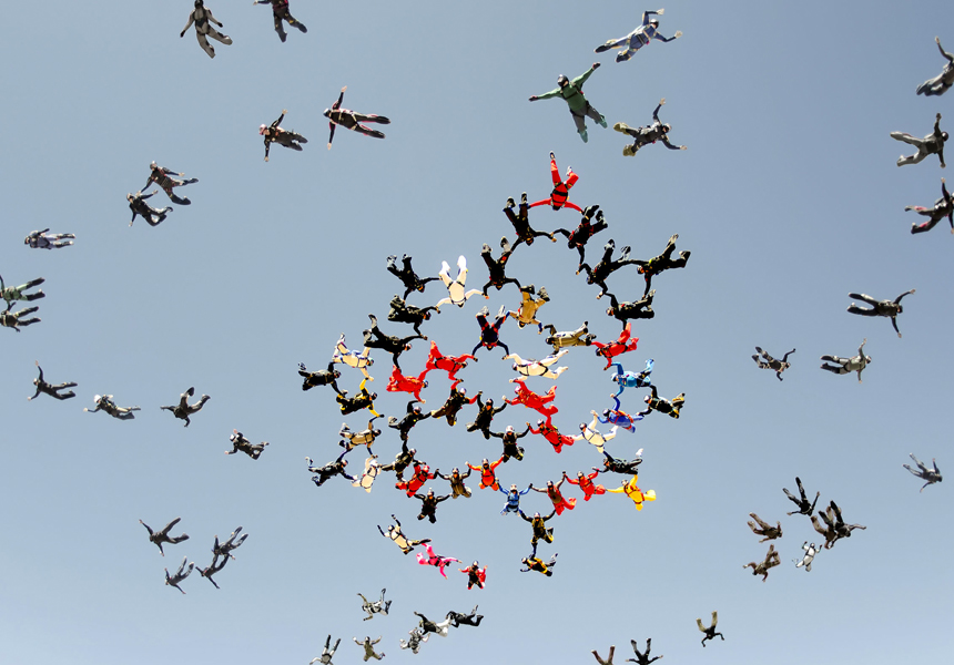 Sky divers floating through a clear sky