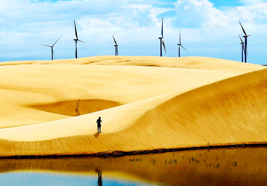 Wind turbines sit on a desert horizon.