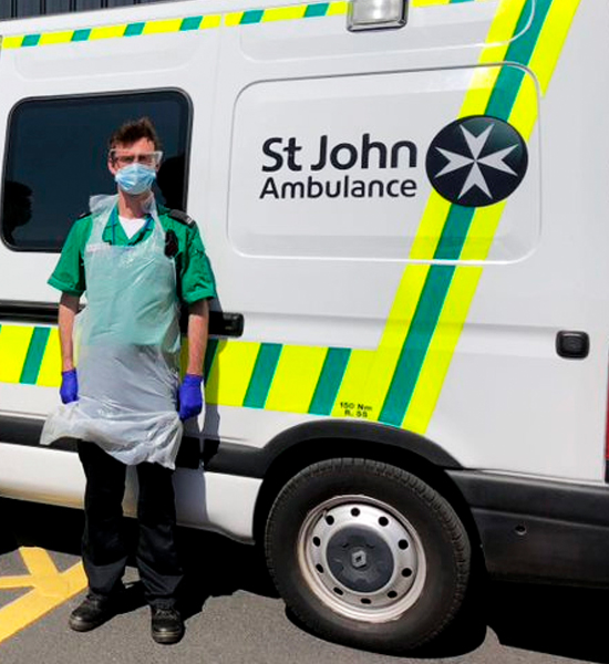 A first responder standing along side of a St. John's ambulance