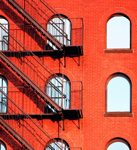 A red brick building with a fire escape on the exterior