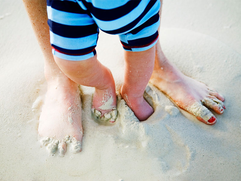 Mother and baby feet on the beach