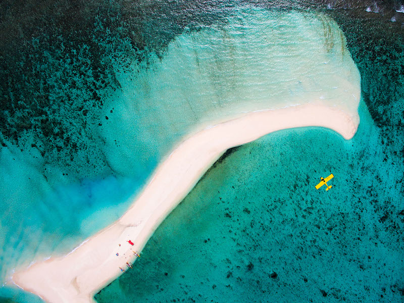 avion survolant une petite île au milieu de la mer