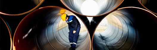 Construction worker inside big pipes