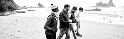 Menschen gehen an einem Strand entlang