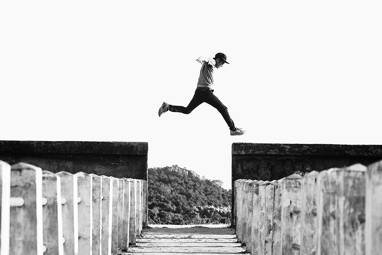 Image of a man jumping over a wall.