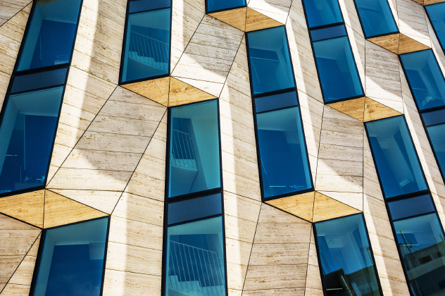 A building featuring numerous windows with vibrant blue architectural design