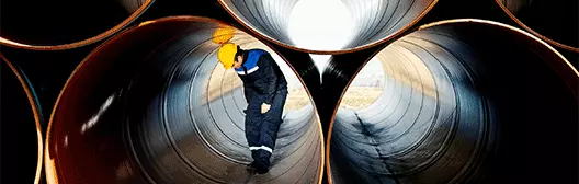 Worker going through a tunnel on construction site.