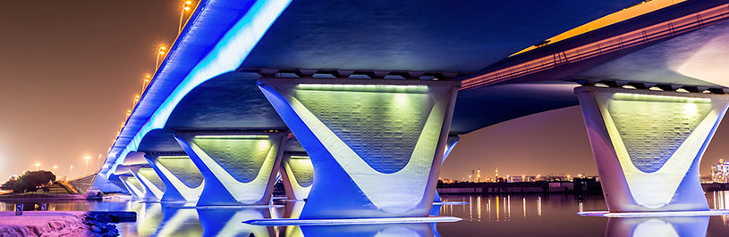 Brücke bei Nacht mit bunter Beleuchtung der Pfeiler