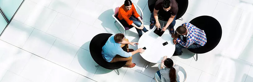 5 Menschen sitzen um einen Tisch herum