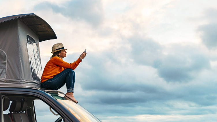 Lady sitting on a car with a car tent setup for travelling