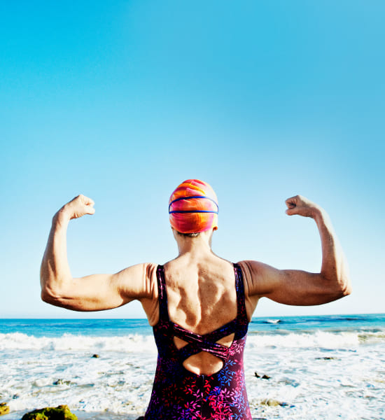 Overlooking a sea view with a swimmer flexing in front of the sea