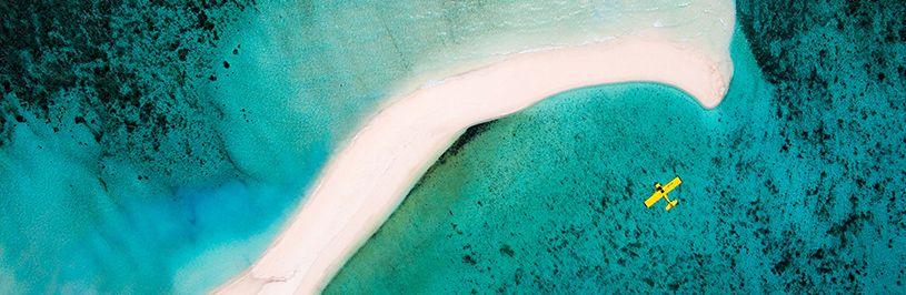 plane hovering over sea