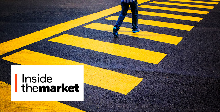 A man is walking across a crosswalk