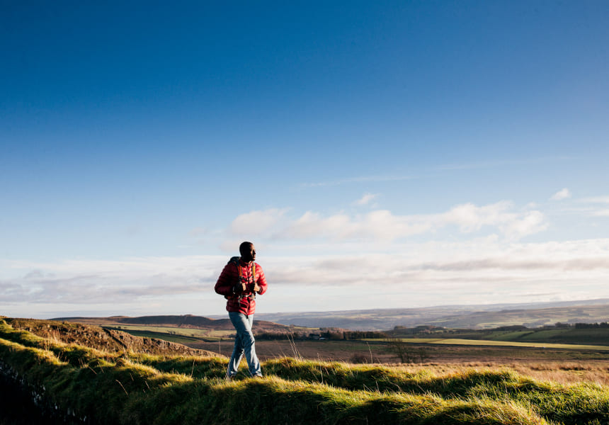 Man hiking on a hill with a view of the city