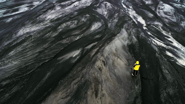 Scientist overlooking volcanic rock