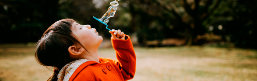 Girl blowing bubbles in a park