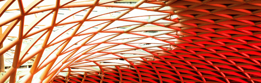 Curved architectural ceiling with geometric lattice pattern in red and gold tones