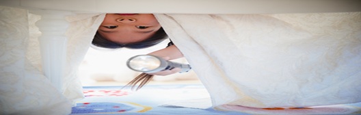 Image shows girl searching under bed with torch.