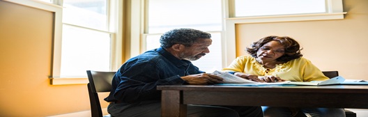 Image shows two people discussing documents.