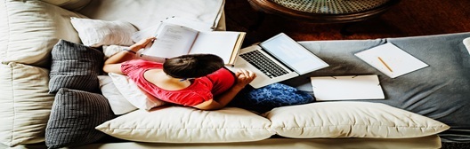 Image shows a woman working on a couch