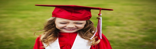 Image shows child in graduation cap and gown