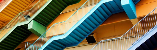 Colourful zigzag exterior staircases in red, green, blue and orange on a building facade