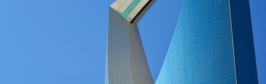 Close-up of a modern skyscraper with a distinctive curved inverted arch against a blue sky