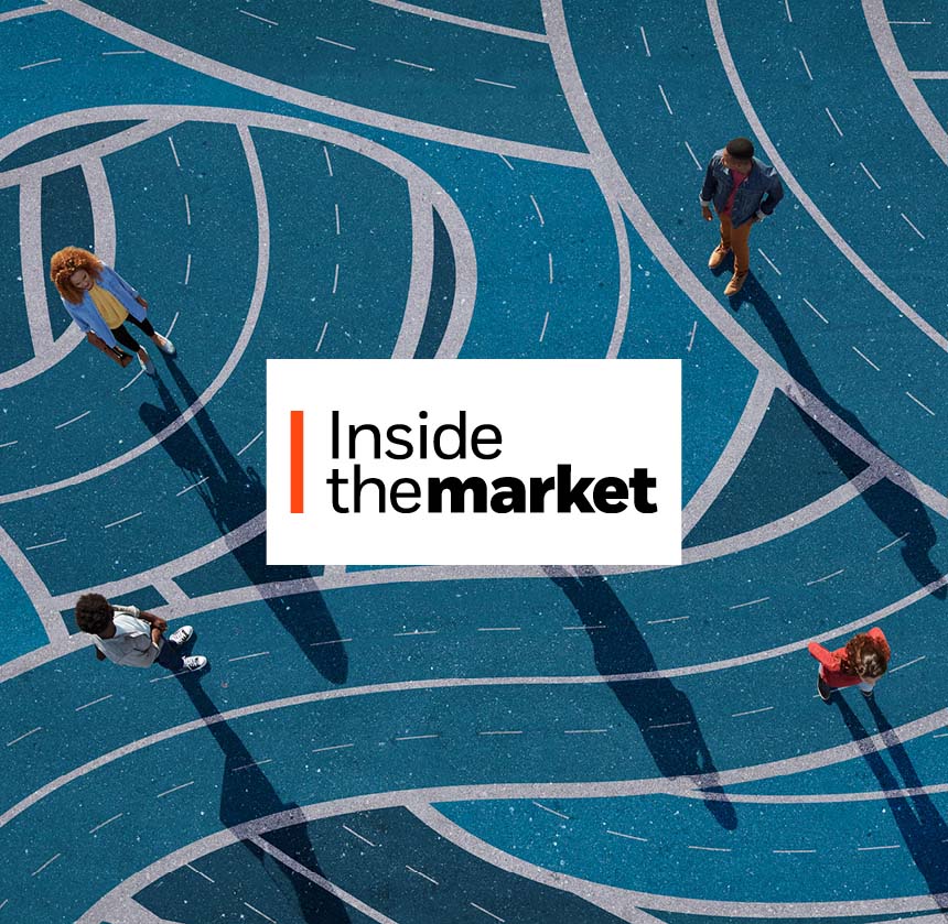 Aerial view of people walking across a blue surface covered with intersecting curved lines, casting long shadows.