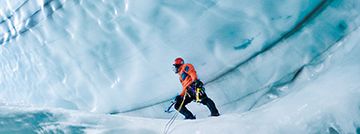 Langjokull Glacier, Iceland. Caves are formed from either hot springs underneath glacier or meltwater from surface. Climber is 80 feet below surface of glacier