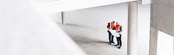 Construction workers evaluate a blueprint.