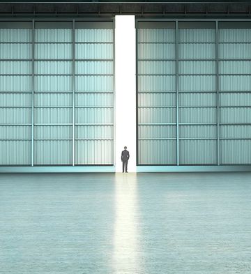Empty hangar with one open door by day