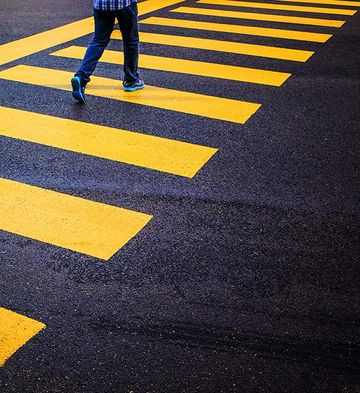 Photo of man walking across a pedestrianized road highlighting the yellow walkway