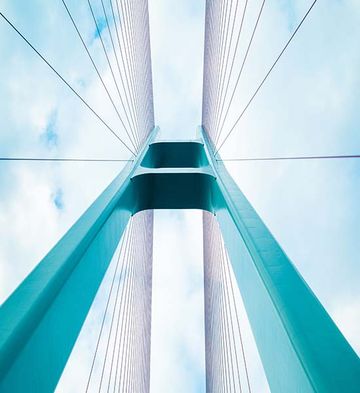 Photo of a tall blue and grey bridge representing infrastructure
