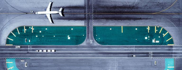 Aerial view of an airplane taxiing on a runway..