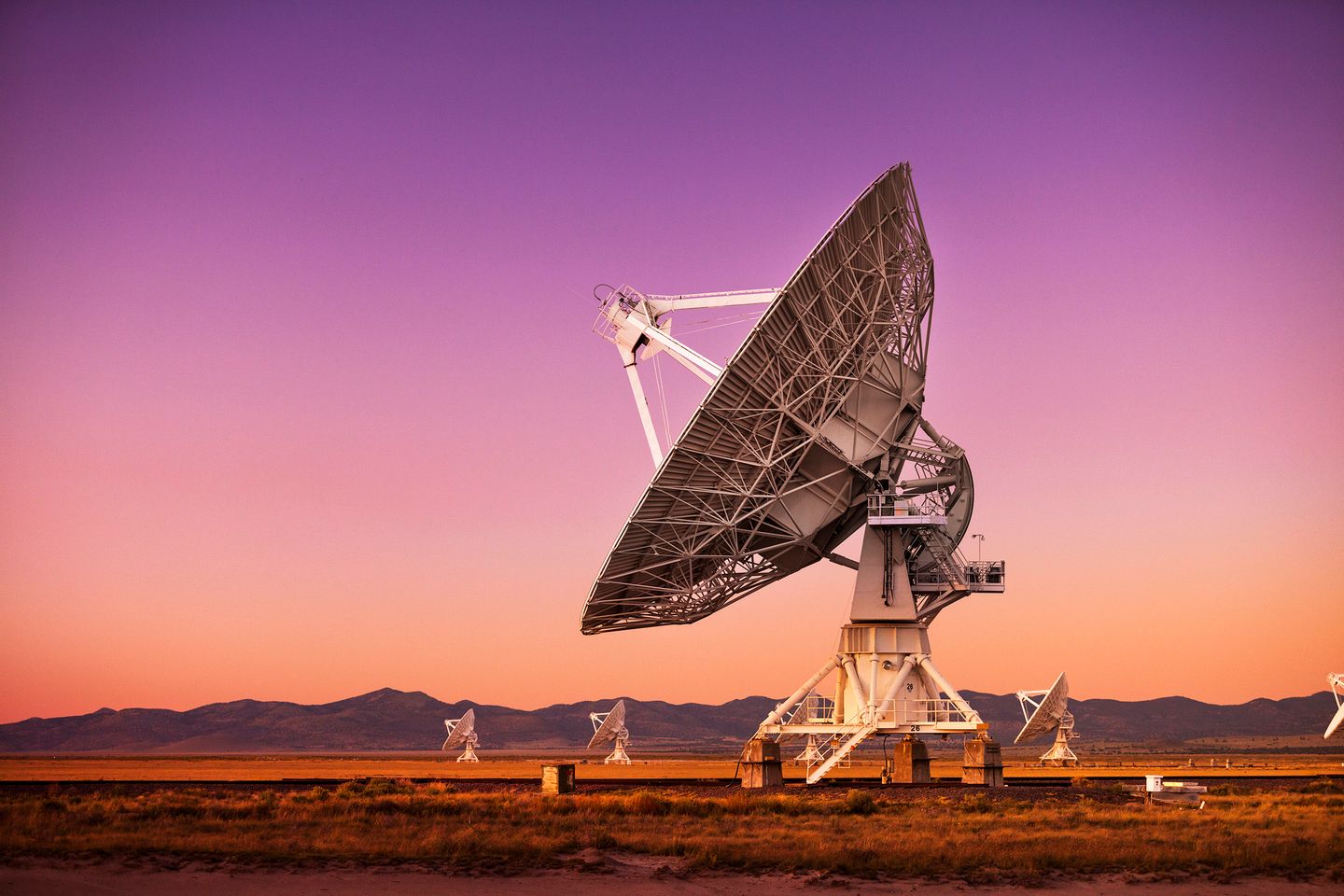 Satellite dishes in a desert at sunset