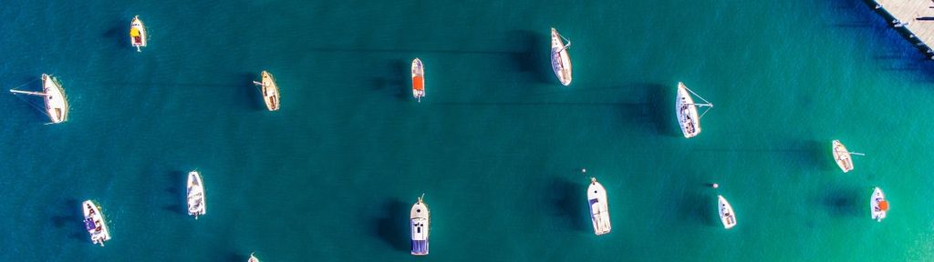  Aerial view of boats anchored in clear blue water.
