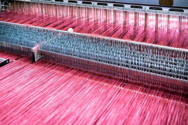 Thread machine making pink thread.