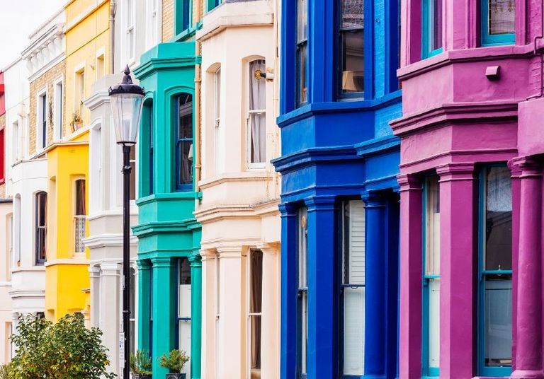 Banner image of colorful row houses with a streetlamp in the foreground.