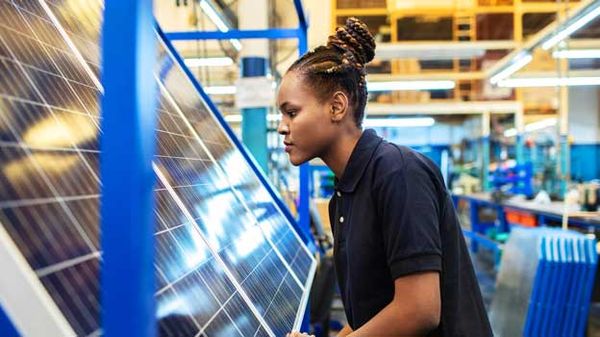 A woman works in a factory, highlighting the role of modern communication in enhancing retirement plan engagement.