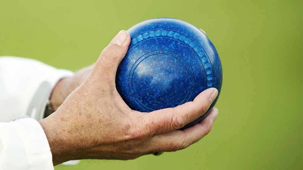 hand holding blue bocce ball