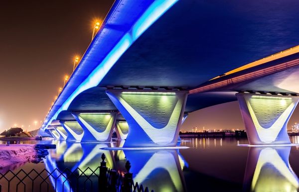 Night view of a lit-up bridge symbolizing infrastructure and private market assets in a 401k