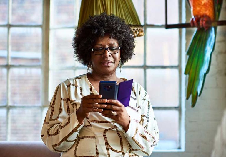 A woman checks her phone, highlighting the significance of understanding retirement and defined contribution options