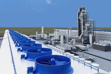 Modern industrial plant with blue cooling fans and tall processing structures under a clear sky.